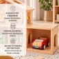 Preview: Kind spielt an einem Holzpuppenhaus mit angebauter Garage, rotem Auto und eingerichteten Zimmern
